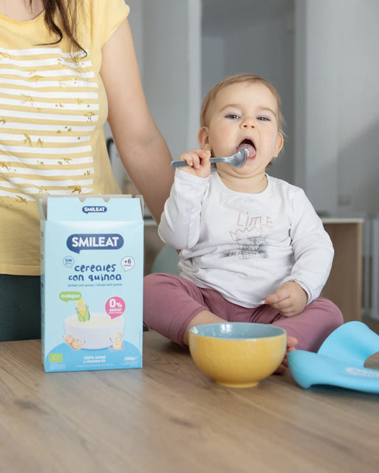 Bebé comiendo papilla de cereales con quinoa SMILEAT sin azúcar añadido