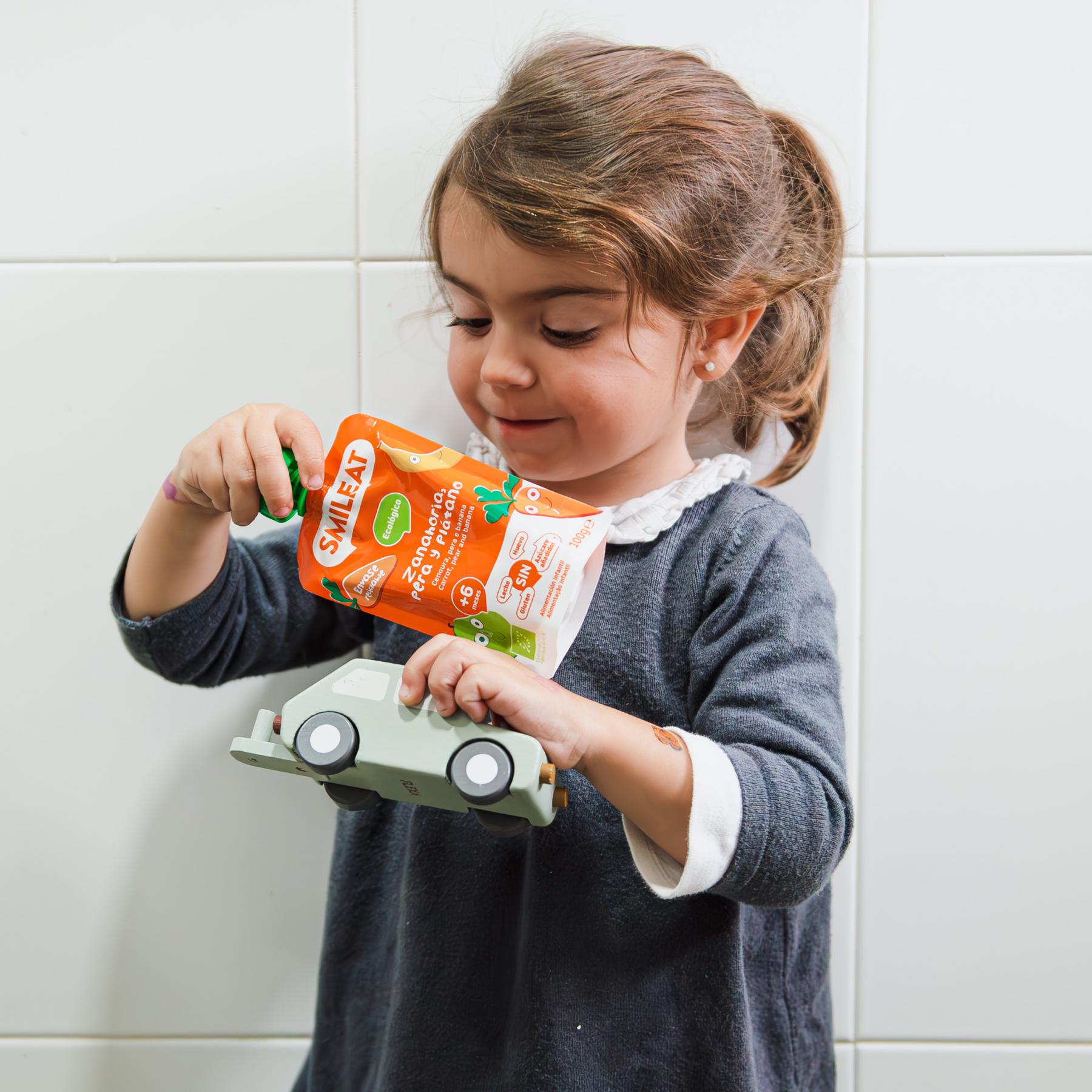 bebé comiendo un pouch de zanahoria, pera y plátano