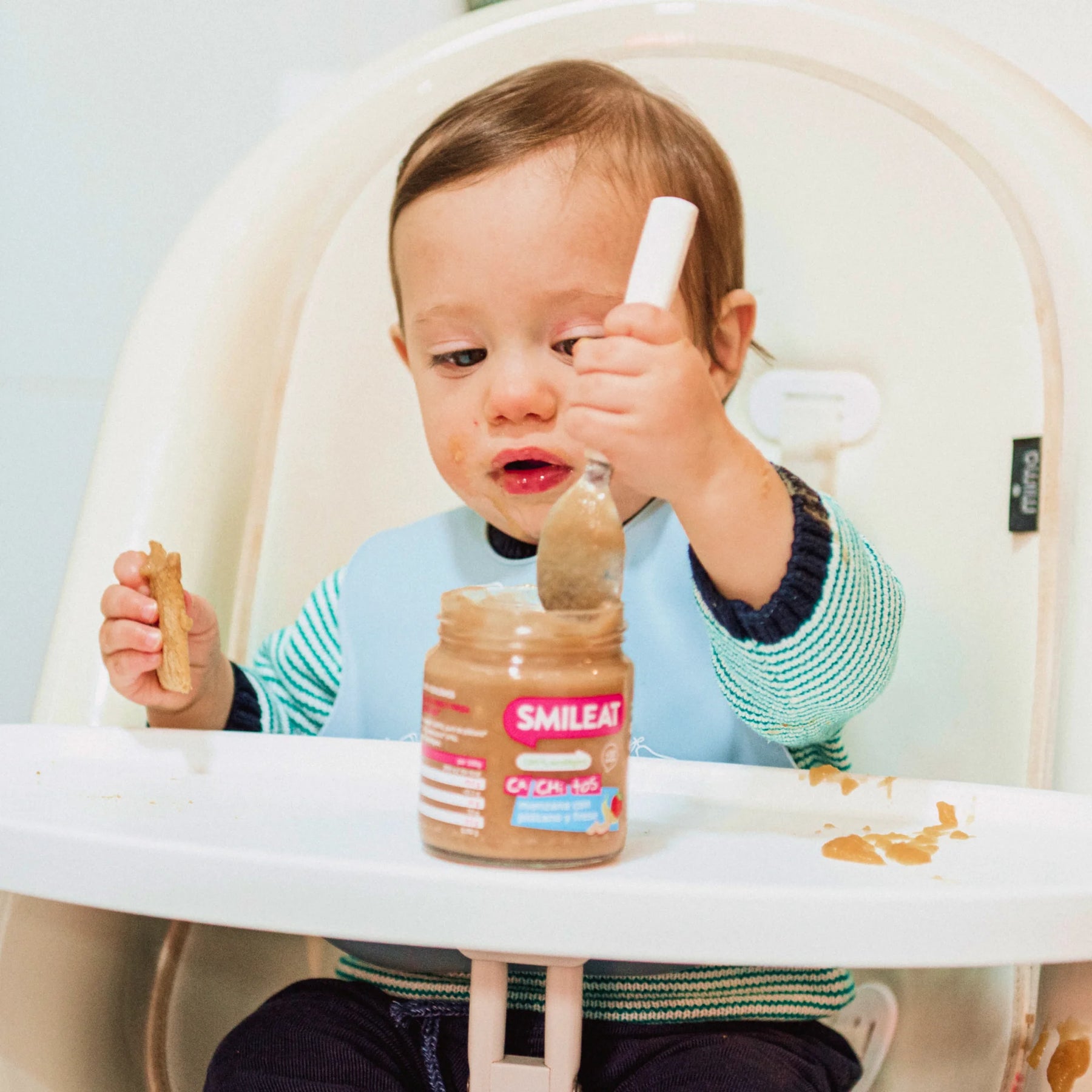 bebe comiendo tarrito de manzana con platano y fresa