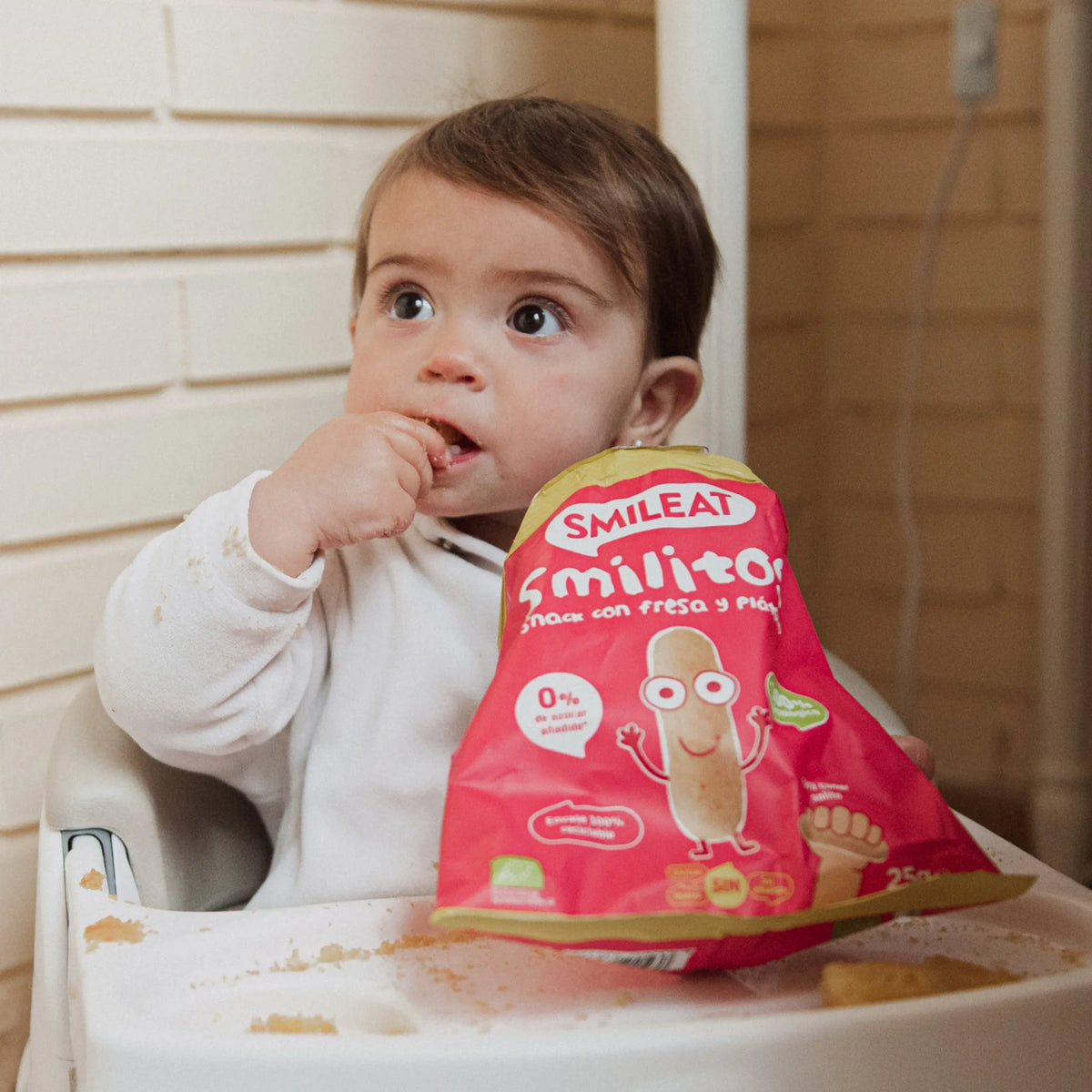 baby eating strawberry and banana chips