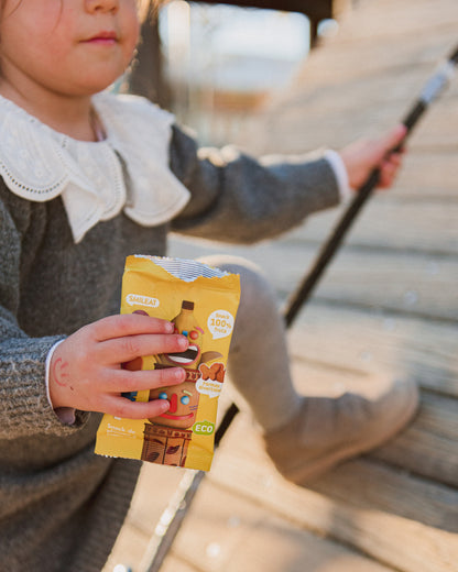 A girl eating an apple and banana snack in the park