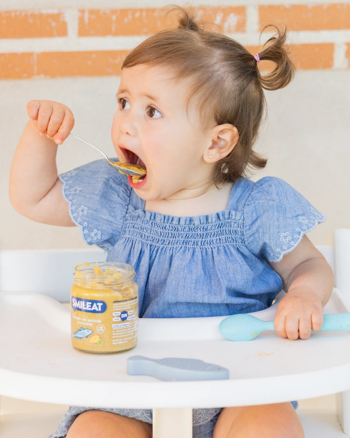 Bebé comiendo tarrito ecológico Smileat de bacalao con verduras, comida infantil para alimentación complementaria desde 6 meses