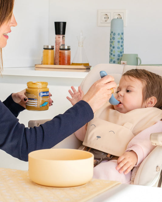 Bebé comiendo tarrito ecológico Smileat de bacalao con verduras, comida infantil para alimentación complementaria desde 6 meses