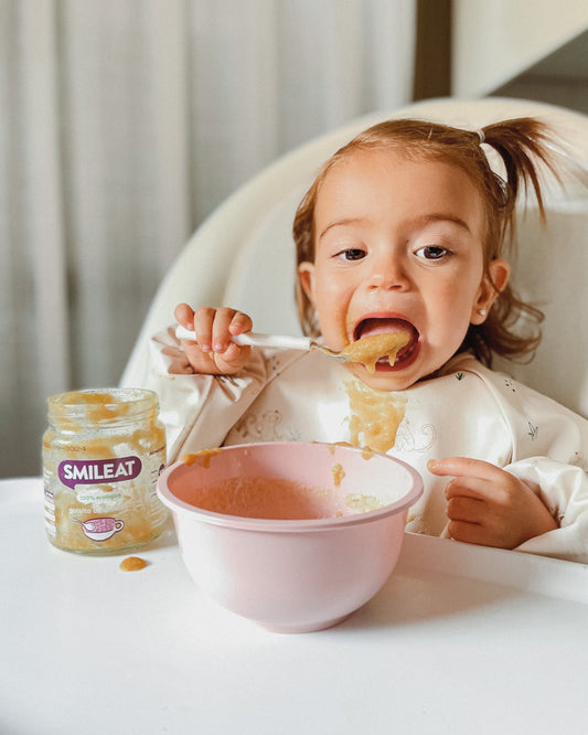 Bebé comiendo tarrito ecológico Smileat de guisito de alubias, comida infantil para alimentación complementaria desde 6 meses