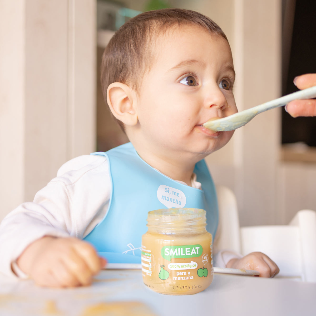Child eating organic pear and apple fruit jars
