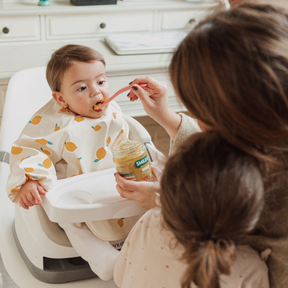 baby eating a small jar of broccoli, lamb and parsnips