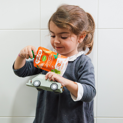 bebé comiendo un pouch de zanahoria, pera y plátano