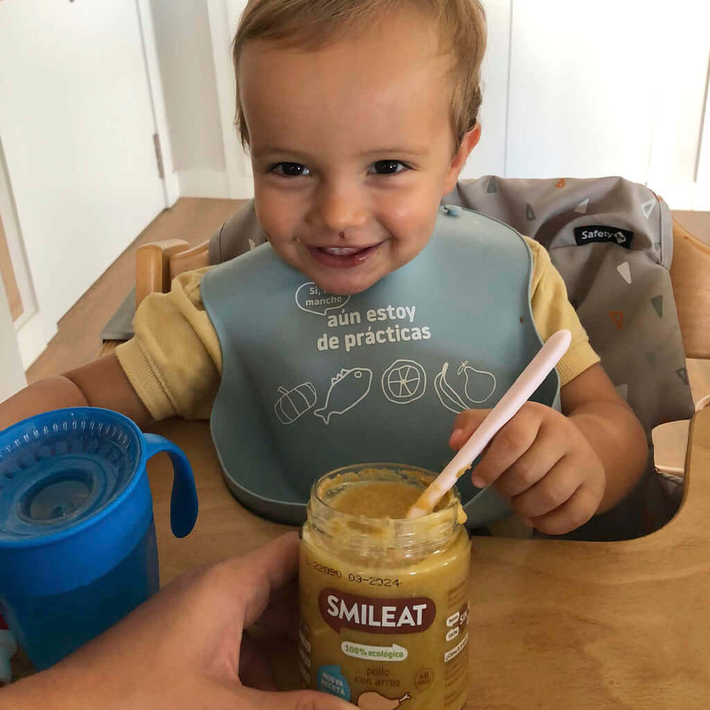 baby eating a small jar of chicken with rice